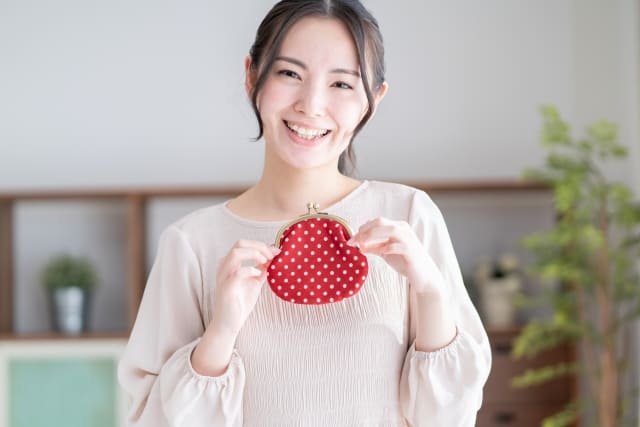 財布を持って喜ぶ女性